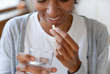 Close up happy young african american young woman taking probiotics