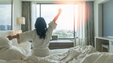 woman waking up refreshed in her bedroom