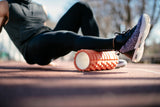 woman using foam roller on right calf