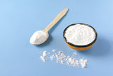 Collagen powder in a bowl and on a spoon on blue background