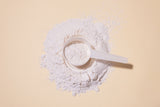 collagen powder on a beige background with a scoop
