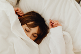 woman sleeping in white sheets