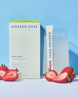 Modern Dose Biotic Blend drink with a stick pack and its supplement box on a blue background - www.moderndose.com