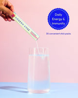 Hand pouring a Modern Dose Essential Health into a glass with a pink background with badge text "daily energy & immunity"