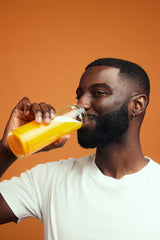 happy male customer drinking Modern Dose Citrus Joint Support with an orange background - www.moderndose.com