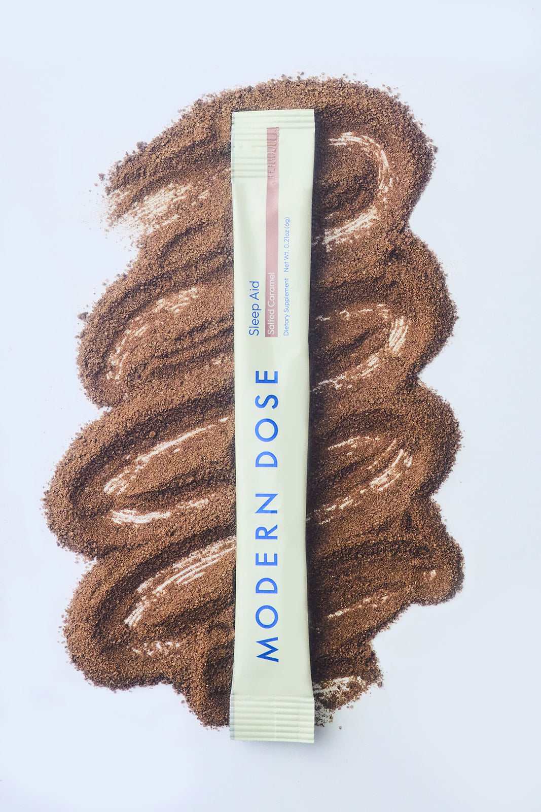 Modern Dose Sleep Aid Salted Caramel stick pack laying over its powder - www.moderndose.com
