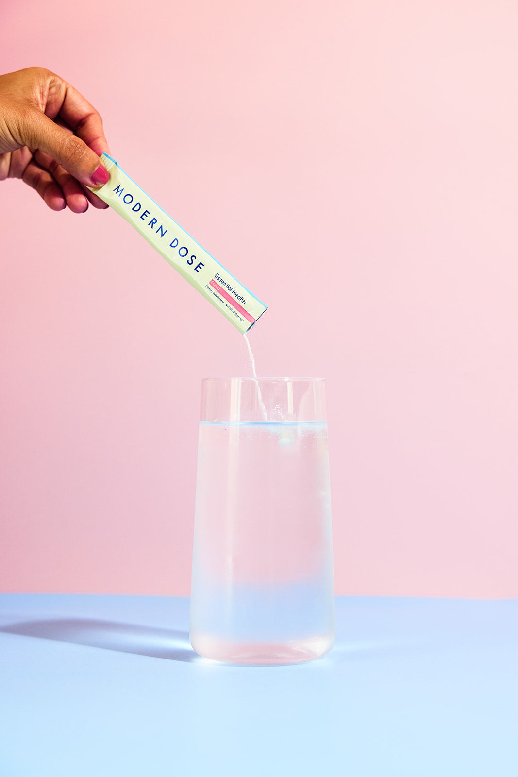 Modern Dose Essential Health powder being poured into a glass of water - www.moderndose.com