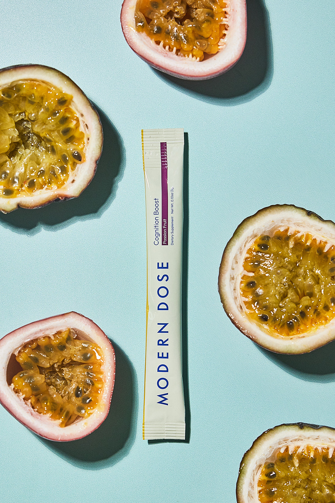 Modern Dose Cognition Boost stick pack in passion fruit surrounded by sliced passion fruit - www.moderndose.com