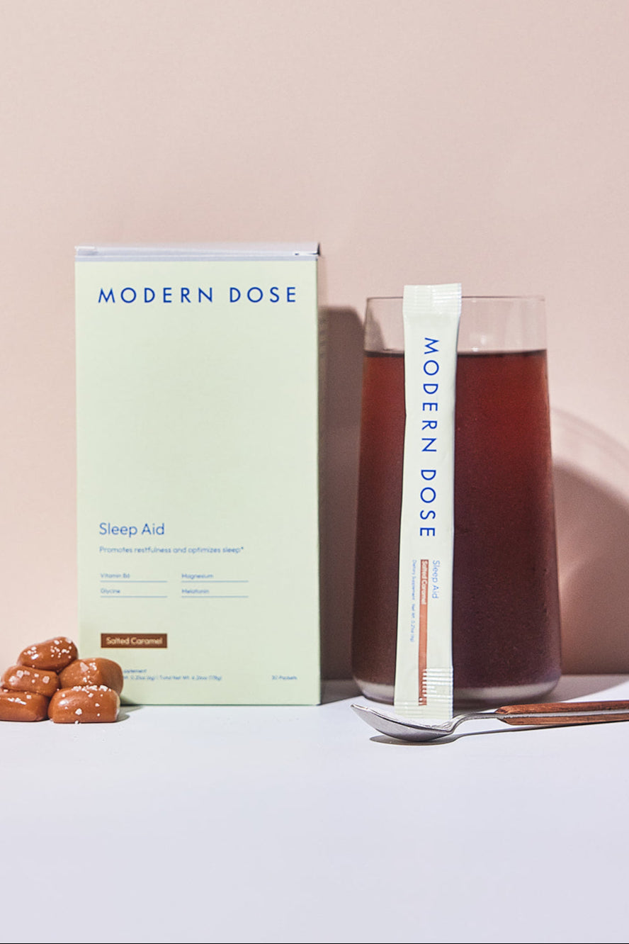 Modern Dose Sleep Aid Salted Caramel box, stick pack, and drink with salted caramel and a spoon
