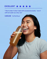Positive review on Modern Dose Stress & Mood Balance and image of woman smiling while drinking Stress & Mood Balance on a light blue background